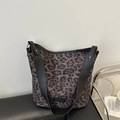 Grande borsa tote leopardata con cinturini in pelle nera su un'elegante panca in pelle - Leopardo Nero