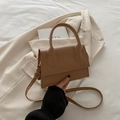 Minimalist light brown PU leather handbag with long adjustable strap on beige suit blazer - Khaki