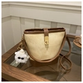 Detail of canvas bucket bag with leather trim and plush monster charm on table - With White Glasses Charm / Brown