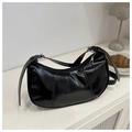 Close-up of black glossy crescent bag featuring silver zipper and adjustable strap - Black