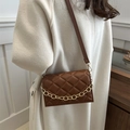 Brown quilted crossbody bag with gold chain strap worn with cream coat - Coffee