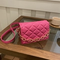 Quilted rose pink crossbody mini bag with gold chain strap on a coffee table - Rose Pink