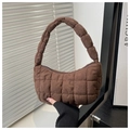 Detalle de un bolso hobo acolchado marrón que muestra la textura suave y forma de luna - Marrón