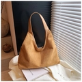 Dettaglio artistico di una borsa hobo in pelle scamosciata marrone su tessuto - Marrone