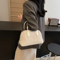 Retro beige matte suede Boston handbag with white handles shown on arm in a chic setting - Beige