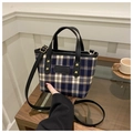 Detailed close-up of retro plaid bucket bag with gold studs and leather handle detail - Black