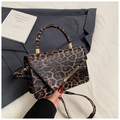 Detail of leopard print shoulder bag with gold metal hardware and rounded top handle - Brown
