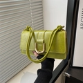 Detailansicht der avocadogrünen Ledertasche mit goldener U-Schnalle und geknotetem Riemen - Grün
