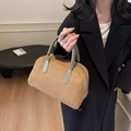Retro brown suede Boston handbag with contrasting light green handles in a handheld pose - Khaki