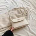 Chic cream white crossbody bag with metal bow detail on soft fabric background - Off White