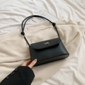 Minimalist black faux leather crossbody bag with a silver metal bow accent - Black