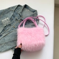 Pluche roze handtas van imitatiebont met schouderriem op een spijkerjasje gelegd - Roze