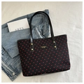 Flat lay of black tote bag with red heart prints and gold metal logo plate detail - Black Heart