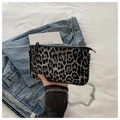Close-up of leopard print crossbody bag with silver studs and metal chain strap details - Black