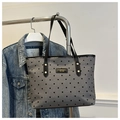 Detailansicht der grauen gepunkteten Tragetasche mit schwarzen Riemen und Logo-Patch - Schwarzer Polka Dot