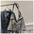 Detail of leopard print canvas tote bag with zippers and bow decoration on denim background - White