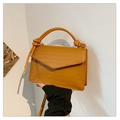 Détail du sac à main jaune à texture crocodile avec bandoulière nouée et boucles métal - Fauve