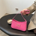 Chic pink underarm bag featuring a metallic gold bow and sleek faux leather finish - Rose Pink