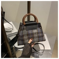Close-up of retro plaid handbag featuring textured wool fabric and brown resin handle - Black