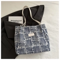 Detail of blue and white abstract line pattern tote bag with white leather strap on suit - Blue Without Charm
