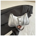 Close-up of a silver metallic baguette bag with a square buckle on a black blazer - Silver