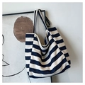 Detail einer marineblauen gestreiften Canvas-Tasche mit dicken Schultergurten an einem Rahmen - Blau