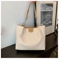 Primer plano del bolso tote beige con detalles de cadena plateada y textura de ecocuero - Caqui