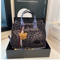 Dettaglio della borsa tote in tela leopardata con manici viola e ciondolo a forma di orsetto - Blu (Con Ciondolo)