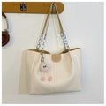 Detalle de bolso tote crema con correa de cadena metálica y colgante de peluche rosa - Tipo estándar / Caqui