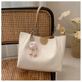 Detalle del bolso tote de cuero blanco crema con cadena plateada y colgante de peluche - Con Colgante / Caqui
