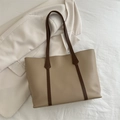 Bolso tote grande caqui claro con asas marrón oscuro sobre un fondo beige minimalista - Caqui