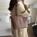 Bolso tote grande de cuero sintético marrón mostrado en modelo para estilo de oficina - Marrón Oscuro