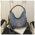 Close-up of blue denim tote bag with brown leather straps and silver metal M logo - No Pendant / Blue