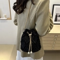 Black canvas bucket bag with quilted patterns, frayed edges, and white pearl drawstrings - Black