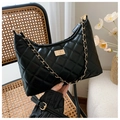 Detailed view of black quilted crescent bag with gold chain on vintage rattan chair - Large (30x22x9cm) / L Black