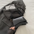 Sac à main noir en similicuir crocodile avec boucles dorées et bandoulière réglable en vue - Noir