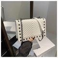 Detail of white quilted handbag featuring dark metal studs and silver chain strap - White