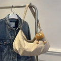 Bolso hobo beige con textura plisada y colgante de peluche en soporte metálico - Caqui Con Colgante
