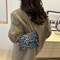 Chic leopard print chain shoulder bag with gold hardware worn over a stylish blazer - Black