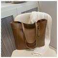Gros plan d'un sac cabas en cuir marron avec coutures contrastées blanches et doubles anses - Marron