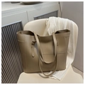 Détail du grand sac cabas en cuir kaki avec surpiqûres structurelles sur une chaise - Kaki