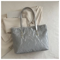 Close-up of a silver tote bag with pleated texture, gold rivets, and a gray shoulder strap - No Pendant / Silver
