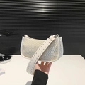 Beige geflochtene Achseltasche mit dekorativen Metallnieten am breiten Schultergurt - Weiß