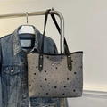 Star pattern canvas tote bag with black bow and leather straps hanging on a rack - Star
