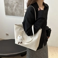 Chic beige tote bag with cute plush pendant shown on shoulder for daily styling - Beige With Charm