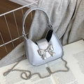 Mini silver bow crossbody bag with metallic finish and chain strap on stylish background - Mini Silver