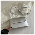 Close-up of silver metallic square bag featuring bow detail and knotted shoulder strap - Silver