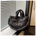 Detalle de bolso acolchado negro tipo nube con textura de nylon y asas resistentes - Negro