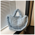 Detalle del bolso tote acolchado azul claro con textura mullida y correas de hombro - Azul