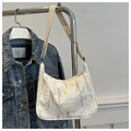 Détail d'un grand sac bandoulière en nylon avec broderie colorée sur tissu blanc cassé - Blanc